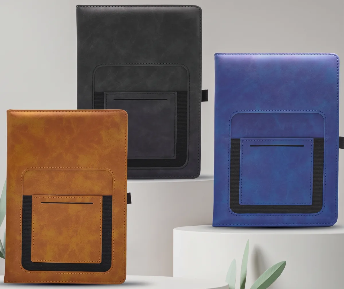Three notebooks in tan, black and blue with front pockets and elastic bands